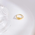 Macro shot of 18K gold-plated signet ring with inlaid clear zircon and star detail - US 6 / Star Single Zirconia
