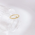 Detail of 18K gold plated ring featuring a small round zircon set on a slim band - US 6 / Offset Diamond Design