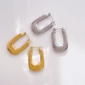 Dettaglio macro di orecchini a cerchio a U in oro e argento con trama a coste - Filettato Cavo (Oro)