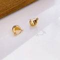 Dettaglio degli orecchini a cerchio bombati dorati con finitura lucida su fondo bianco - Piccola Mezzaluna (Oro)