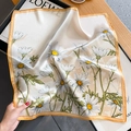 Silk square scarf with daisy print and orange border draped over a magazine - 53x53cm / Beige