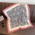 Detalle de un pañuelo de seda floral con bordes rosas sobre cuero marrón - Rosa / 70x70cm
