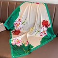 Elegant lotus silk scarf with green border draped over a leather sofa in champagne - 70*70cm / Beige and Green