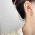Elegante gouden ronde schijfoorbellen met parel en zirkoon op een model oor - Kleine Schijf Klein (1,1 cm)