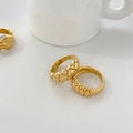Primer plano del anillo dorado con diseño acolchado y texturas metálicas finas - US 6 / Estilo Acolchado