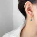 Elegant gold hoop earrings with a square blue zircon pendant shown on a model - Square Lake Blue Zirconia