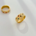 Détail macro de bagues larges dorées avec motifs d'étoiles et cœurs en émail coloré - Style Zircone Multicolore