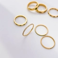 Close-up of gold-plated titanium steel rings featuring green stones and micro-pave crystals - US 6 / White Zirconia Pavé Band