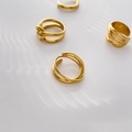 Dettaglio di quattro anelli minimalisti placcati in oro 18 carati con ombre d'acqua soffuse - US 6 / Linee incrociate a doppio strato