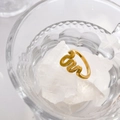 Artistic close-up of gold abstract seagull ring on glass and white mineral stones - Curved Lines / US 6