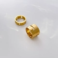 Dettaglio dell'anello in acciaio dorato con stelle e fascia larga minimalista - US 6 / Design Svuotato a Linea Liscia