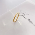 Macro di un anello placcato oro 18 carati con motivi geometrici a rombi e trama sottile - Griglia a rombi convessi