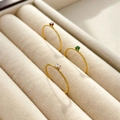 Nahaufnahme goldener Ringe mit Rubinen, Smaragden und Diamanten in Textur - US 6 / Gehämmerter Schmaler Ring Granatrot