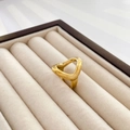 Nahaufnahme eines goldenen abstrakten Dreieckrings in einer Samt-Schmuckschatulle - US 6 / Hohlschlaufe