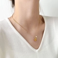 Gros plan d'une fine chaîne serpent dorée avec pendentif goutte et petite perle blanche - Brocche Dorée Avec Pendentif Perle Blanche
