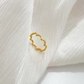 Dettaglio dell'anello ondulato in oro su tessuto bianco morbido stile minimalista - US 6 / Onda marina