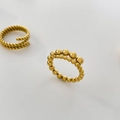 Detail eines 18K vergoldeten Perlen-Wellenrings und mehrlagigen gedrehten Seilrings - US 6 / Runde Perlen in verschiedenen Größen