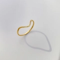Dettaglio macro dell'anello a V dorato con micro zirconi e design della fascia a onde - US 5 / Punta Curva Singola