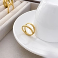 Detailed view of polished double-layered gold ring leaning on a white ceramic cup edge - US 6 / Thin Double Layer