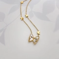 Detail of 18K gold plated butterfly necklace featuring mother of pearl inlay and mini charms - Shell Butterfly
