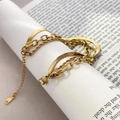 Close-up of triple-layered gold bracelet with snake, ring and twist chain textures - Triple Layered Chain Style