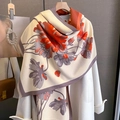 Dettaglio di sciarpa in cashmere a fiori drappeggiata su un cappotto beige in interni - 65*185cm / Arancione Grigio Riso