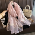 Détail d'une écharpe en soie rose avec broderie papillon, perles et rayures dorées - Rose poudré