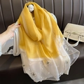 Détail d'une écharpe en soie avec broderie papillon et perles sur bordure en tulle - Jaune