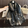 Détail d'une écharpe en soie noire avec broderie papillon et perles sur tissu rayé - Noir