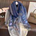 Detailed close-up of blue floral embroidery on navy silk wool scarf with gold trim - Navy Blue