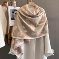 Détail d'une écharpe fleurie épaisse avec franges sur un manteau blanc élégant - Rose Café