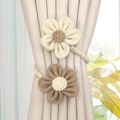 Close-up of floral curtain tieback with woven texture on a beige fabric drape - Two Small Beige & Coffee Flowers