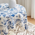 Dettaglio di una tovaglia rotonda in cotone e lino con motivi botanici blu e nappe decorative - 60*60cm / Fiore di Begonia
