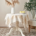 Beige and white plaid round tablecloth with tassels on a wooden dining table - Beige Checkered