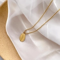 Vue macro détaillée du pendentif ovale plaqué or 18K et de la chaîne torsadée sur soie blanche - Plaque Ovale Marguerite