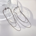 Detailansicht der dreilagigen silbernen Schlangenkette Fransenohrringe auf Glas - Stahlfarbene Dünne Schlangenkette Quaste