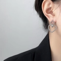 Close-up of silver-tone twisted texture heart earrings worn by a model in a black suit - Steel Twist Line Heart Earrings