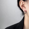 Minimalistische silberfarbene Creolen getragen mit einem schwarzen Profi-Blazer - Stahlfarbenes UFO Flache Creolen