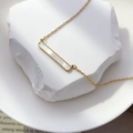 Primer plano de collar dorado con colgante rectangular e incrustación de nácar blanco - Concha de barra
