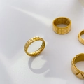 Detail von vier 18K vergoldeten stapelbaren Ringen mit Rillen und Schicht-Design - US 6 / Kleines Rechteckiges Zahnrad