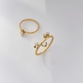 Makroaufnahme des 18K vergoldeten Titanrings mit funkelnden Zirkoniasteinen in Krappenfassung - US 6 / Asymmetrische 5-Zirkon