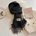 Close-up of black and beige cashmere-feel scarf with elegant fringe and brand label - Black Beige