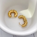 Macro detail of gold-plated ribbed hoop earrings with a textured bamboo style finish - Bamboo Style