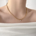 Primo piano di una collana placcata oro 18K con pendente a diamante solitario su una modella - Catena Grossa con Zirconia da Un Carato (Oro)