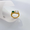 Macro detail of gold-plated wide ring with emerald and clear rectangular zircons - US 6 / Two-Tone Square Zircon