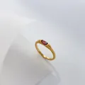 Detailed macro view of a gold ring featuring an oval red zircon and textured band - US 6 / Red Zirconia
