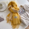 Detalle de bufanda bicolor amarillo y beige efecto cachemir con flecos y etiqueta - Amarillo