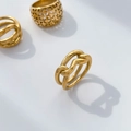 Macro view of interwoven 18K gold plated titanium ring with hollow twisted line texture - Abstract Lines Heart Hollow