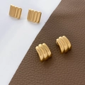 Detail of gold-plated geometric earrings showing vertical ribs and croissant wave textures - Vertical Ribbed Style