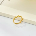 Dettaglio di un anello con motivo a onde irregolari dorato su uno sfondo crema tenue - US 6 / Stile Onda (JZ319)